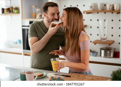 Young Couple Making Sandwich At Home. Loving Couple Enjoying In The Kitchen