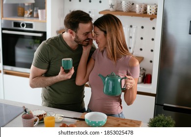 Young Couple Making Sandwich At Home. Loving Couple Enjoying In The Kitchen	