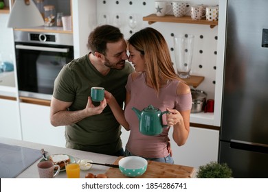 Young Couple Making Sandwich At Home. Loving Couple Enjoying In The Kitchen	