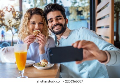 Young Couple Making A Selfie With Smartphone During The Breakfast In A Cafe. Love, Dating, Food, Lifestyle Concept