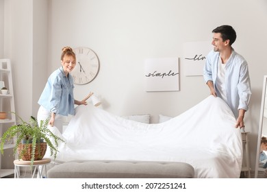Young couple making their bed