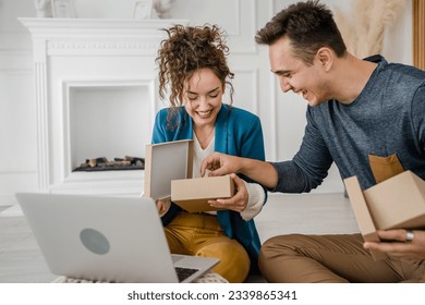 young couple man and woman boyfriend and girlfriend or husband and wife exchange gifts at home giving presents to each other and opening box happy smile celebrate valentine holiday or birthday - Powered by Shutterstock
