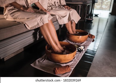 Young couple man and woman dipping their feet in a bowl, waiting for the spa staff to cleanse. Feet in a bowl of floral scented water at the spa center. - Powered by Shutterstock