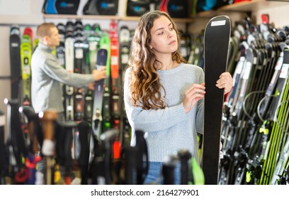 Young Couple Man And Woman Make Purchase Together, Choosing New Skis In A Sport Goods Store