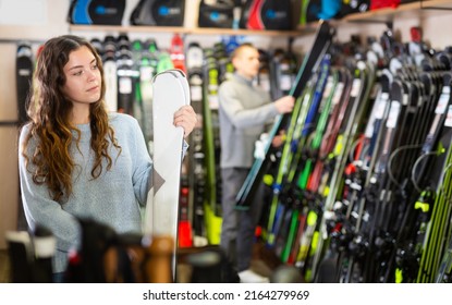 Young Couple Man And Woman Make Purchase Together, Choosing New Skis In A Sport Goods Store