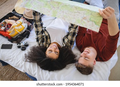 Young couple with map packing for holiday at home. - Powered by Shutterstock