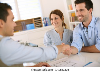 Young Couple Meeting Construction Planner