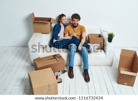  young couple moved to a new apartment a woman put her feet on a man boxes with things                            