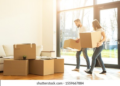 young couple moves to a new home. the family carries boxes of things after buying a home. - Shutterstock ID 1559667884