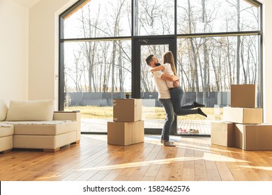 Young Couple Moves To A New Home. The Family Carries Boxes Of Things After Buying A Home.