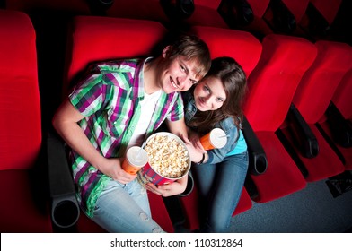 young couple in a movie theater, hugging and happy to have a good time together - Powered by Shutterstock