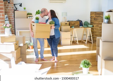 Young couple moving to a new home, smiling happy holding cardboard boxes స్టాక్ ఫోటో
