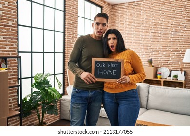 Young Couple Moving To A New Home In Shock Face, Looking Skeptical And Sarcastic, Surprised With Open Mouth 