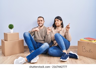 Young Couple Moving To A New Home Pointing Aside Worried And Nervous With Both Hands, Concerned And Surprised Expression 