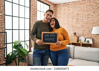 Young Couple Moving To A New Home Smiling And Laughing Hard Out Loud Because Funny Crazy Joke. 