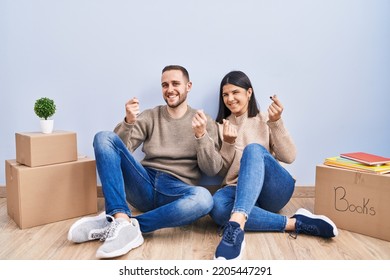 Young Couple Moving To A New Home Doing Money Gesture With Hands, Asking For Salary Payment, Millionaire Business 