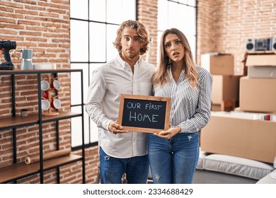 Young couple moving to a new home clueless and confused expression. doubt concept.  - Powered by Shutterstock