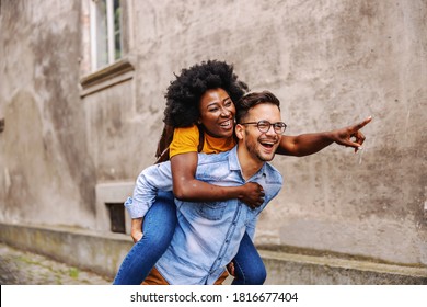 Young couple multiracial couple having piggyback and enjoying free time.