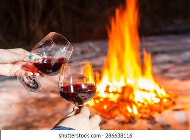 Young couple near the bonfire with two glasses of red wine - Powered by Shutterstock