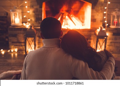 Young Couple Near The Fireplace At Home Winter Hugging Close-up