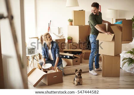 Young couple in new apartment with small dog 