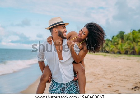 Young Couple On Beach Summer Vacation, Happy Smiling Man Carry Woman Back Seaside