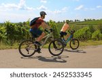 Young couple on a bicycle tour in the vineyards