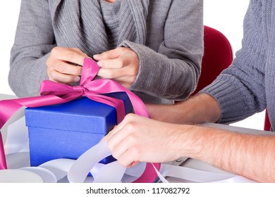 Young Couple On Christmas Eve Wrapping Gift