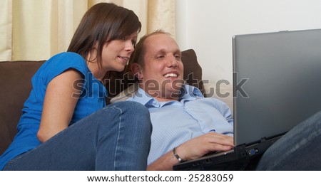 Young couple on the couch at home looking at the laptop!