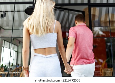 Young Couple On First Date, Outdoor Shot Summer Day. Entering A Cafe Place Together 