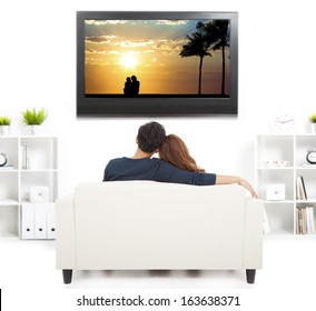 Young Couple On Sofa Watching TV