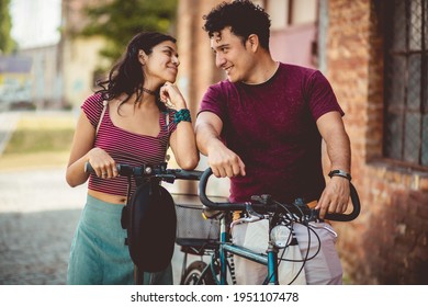 Young couple on the street with bike and electric scooter. 