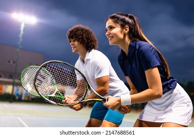 Young couple on tennis court. Handsome man and attractive woman are playing tennis. - Powered by Shutterstock