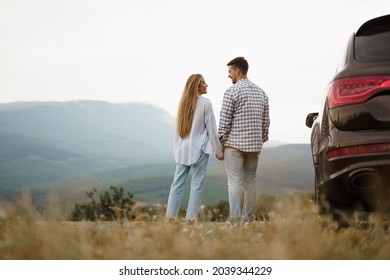Young couple on trip relaxing and enjoying the view of mountains