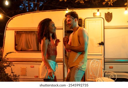 Young couple on vacation with the camper. Dancing outdoor in the night. Concept about wanderlust road trips and lifestyle on vacation - Powered by Shutterstock