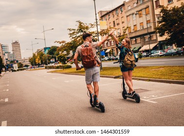 Young couple on vacation having fun driving electric scooter through the city.	 - Shutterstock ID 1464301559