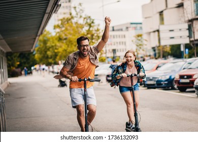 Young couple on vacation having fun driving electric scooter through the city. - Powered by Shutterstock