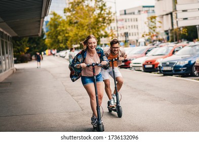 Young couple on vacation having fun driving electric scooter through the city. - Shutterstock ID 1736132096