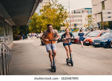 Young couple on vacation having fun driving electric scooter through the city. - Shutterstock ID 1820487890