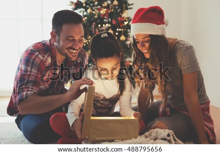 Young couple opening a Christmas present on a Christmas morning