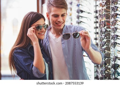 Young couple at optician in the store, they looking for glasses. - Shutterstock ID 2087553139