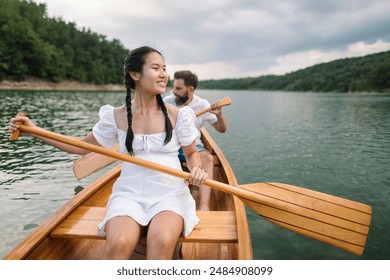 Young couple paddling canoe on a lake - Powered by Shutterstock