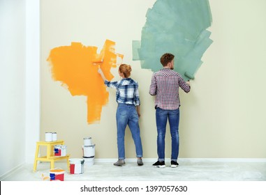 Young Couple Painting Wall Indoors. Home Repair
