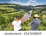 A young couple is photographing the valley with the Berounka river