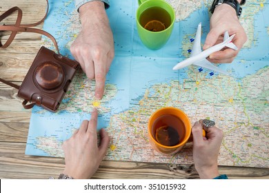 Young Couple Planning A Family Trip To London. Exploring The Map, Develop The Perfect Travel Itinerary . Top View Wooden Table