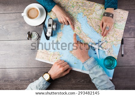 Young couple planning honeymoon vacation trip with map. Top view. Pointing to Europe Rome