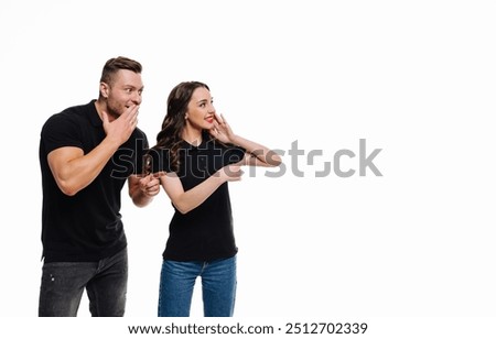 Young couple playfully sharing a secret in a bright studio setting. A man and a woman lean in closely, whispering and sharing a light-hearted secret,
