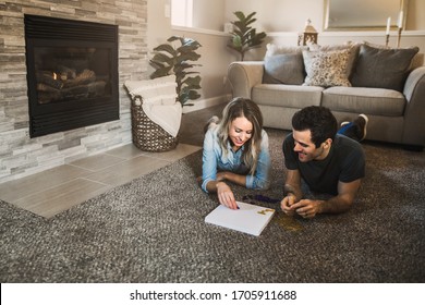 Young Couple Playing A Board Game In Their Cozy Living Room