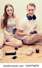 Young couple playing computer game home together, hobby, addiction eat