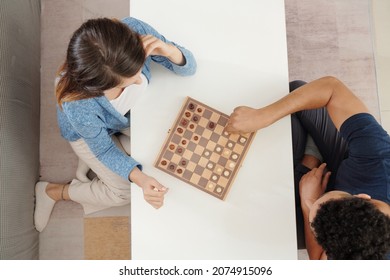 Young Couple Playing Game Of Chess At Home, View From The Top